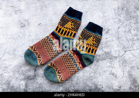 Ein Paar farbenfrohe Winterwollsocken auf grauem Hintergrund. Stockfoto