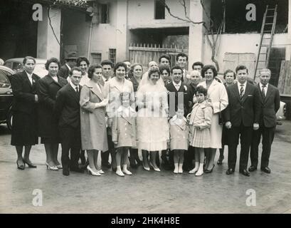 Hochzeit in Italien während des 1950s: Die Braut und der Bräutigam machen das Foto mit allen Gästen Stockfoto