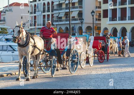 Zakynthos, Griechenland - 14. August 2016: Ein Kutscher lädt Touristen zu einer Fahrt in einer offenen Pferdekutsche ein Stockfoto