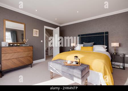 Alconbury Weald, Cambridgeshire - Oktober 17 2016: Modernes, stilvolles Schlafzimmer im Aspiration Chic Home mit hellgelben Bettüberwürfen in hellem Su gebadet Stockfoto