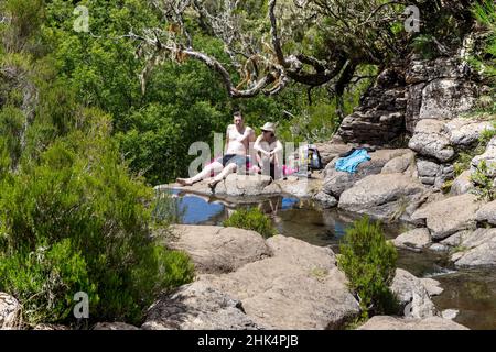 MADEIRA, PORTUGAL - 27. AUGUST 2021: Nicht identifizierte Menschen ruhen in der Nähe eines der Bäche im Raboskal-Naturschutzgebiet. Stockfoto