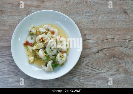 Thailändischer würziger und saurer, gedämpfter Tintenfisch-Salat in Zitronensauce auf dem Teller Stockfoto