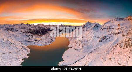 Luftaufnahme des Lago Bianco und der Bernina Pass Straße, die im Morgengrauen die schneebedeckten Berge überquert, Engadin, Graubünden, Schweiz, Europa Stockfoto