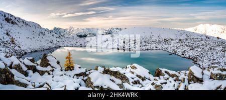 Sonnenaufgang über den schneebedeckten Orobie-Alpen und dem gefrorenen Rogneda-See während eines kalten Herbstes, den Rhätischen Alpen, der Lombardei, Italien, Europa Stockfoto