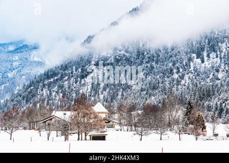 Verschneite Landschaft in den Alpen an einem bewölkten Winternachmittag Stockfoto