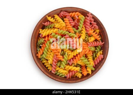 Rohe Fusilli farbige Pasta in Keramikschale isoliert auf weißem Hintergrund mit Clipping-Pfad und volle Schärfentiefe. Draufsicht. Flach liegend Stockfoto