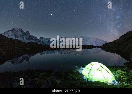 Leuchtendes Zelt unter den Sternen bei Lacs des Cheserys mit Mont Blanc-Massiv im Wasser, Chamonix, Haute Savoie, Französische Alpen, Frankreich, Europa Stockfoto