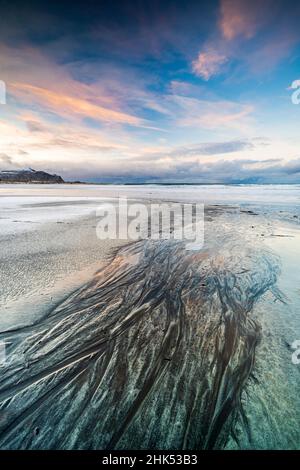 Sonnenuntergang über dem schwarzen Sandstrand von Skagsanden, der im Winter mit Eis bedeckt ist, Flakstad, Nordland County, Lofoten Islands, Norwegen, Skandinavien, Europa Stockfoto