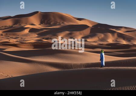 Ein Berbermann in traditioneller Kleidung in den Sanddünen von Erg Chebbi, Sahara-Wüste, Marokko, Nordafrika, Afrika Stockfoto