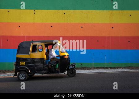 Indian Tuk Tuk passiert eine bunt bemalte Wand in Panjim City, Panjim (Panaji), Goa, Indien, Asien Stockfoto