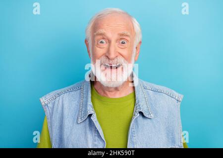 Foto von beeindruckt funky pensionierten Mann tragen Vintage Jeans Weste offenen Mund lächelnd isoliert blauen Hintergrund Stockfoto