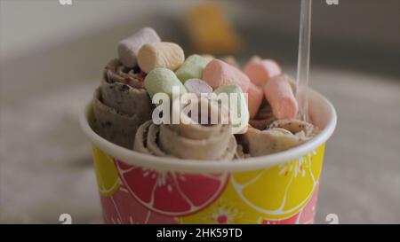 Eisschaufeln auf dem Tisch, Nahaufnahme. Clip. Ein Glas Eis und Süßigkeiten. Stockfoto
