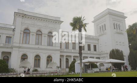 Die Fassade des Liwadia-Palastes in Krim. Aktion. Schöne Fassade eines weißen alten Gebäudes mit Säulen im europäischen Stil. Tourist ehemaliger Palast in Krim. Stockfoto