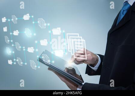 Geschäftsmann berührt Symbole auf dem digitalen Tablet. Document Management System, Online-Dokumentationsdatab Stockfoto