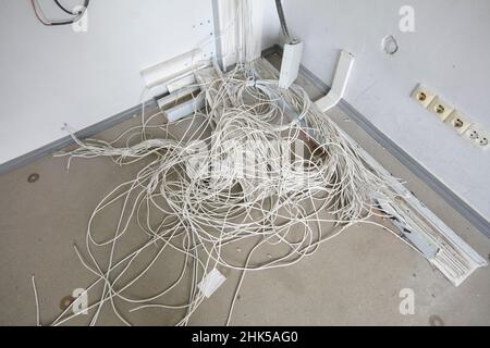 Auf dem Boden befindet sich ein Haufen elektrischer Drähte. Stockfoto