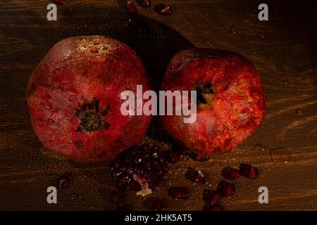 Roter, reifer, nasser Granatapfel auf dem Tisch. Nahaufnahme . Stockfoto