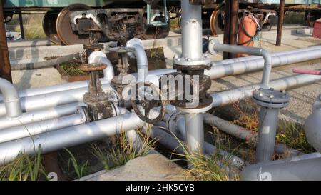 Alte Kraftstoffübertragungsventile an einem Gebäude im Industriegebiet. Lager. Altes Kraftstoffventil im Tanklager. Stockfoto