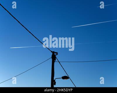 Eine Vision von abstrakter Schönheit und Kontrasten - Straßenlicht, Drähte und Dampfspuren bei Sonnenaufgang, von einem Fußweg in Radley Village aus gesehen. Mein frühes Joggen Stockfoto