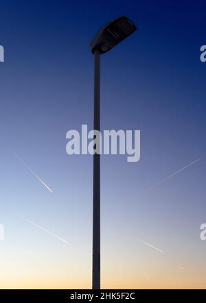 Eine Vision von abstrakter Schönheit und Kontrasten - Straßenlicht und ein Muster von Dampfwegen bei Sonnenaufgang, von einem Fußweg in Radley Village aus gesehen. Mein frühes j Stockfoto