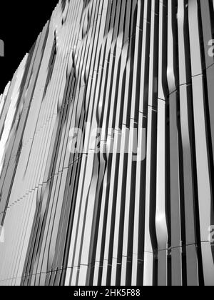 Blick direkt nach oben auf die Fassade eines Parkplatzes auf dem Old Road Campus in Oxford. Sehr linear und modern, auch langweilig, aber die halbverdrehten Platten sind Bogen Stockfoto