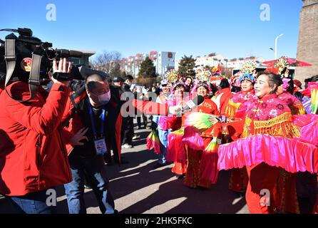 ZHANGJIAKOU, CHINA - 2. FEBRUAR 2022 - Journalisten von nicht registrierten Medien für die Olympischen Winterspiele 2022 in Peking interviewen Menschen, die Volksmusik spielen Stockfoto