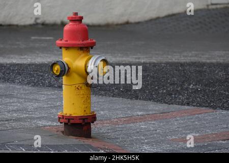 Ein traditioneller rot-gelber Hydrant auf der Straße in Reykjavík Island Stockfoto