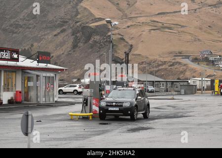 Eine Benzin- und Dieseltankstelle in Vik Island mit Fahrzeugen an den Pumpen mit den schroffen Bergen im Hintergrund Stockfoto
