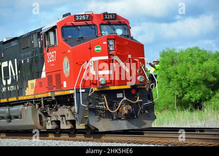 Hoffman Estates, Illinois, USA. Ein Schaffner kehrt mit einem Güterzug der Canadian National Railway auf einem vorbeifahrenden Gleis zur Bleilok zurück. Stockfoto