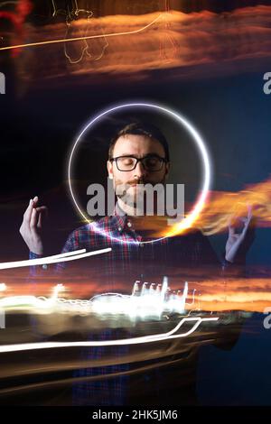 Ein Mann meditiert im Metaverse, umgeben von Lichtern und futuristischen Effekten, um die kreisförmige Harmonie der Energie zu erreichen, die ihn umgibt Stockfoto