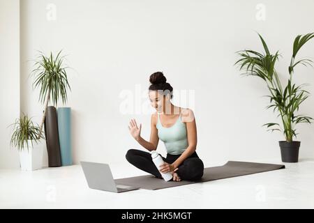 Fernschulungen. Junge Sportliche Frau Mit Online-Yoga-Klasse Mit Laptop Stockfoto
