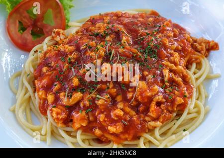 Nahaufnahme der Spaghetti rote Sauce mit dem gehackten Schweinefleisch in der withe Platte für im lokalen Restaurant serviert, Vorderansicht für den Kopierraum. Stockfoto