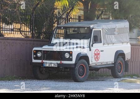 Side, Türkei - 22. Januar 2022: Der weiße Land Rover Defender wird an einem warmen Tag vor dem Hintergrund eines Zauns auf der Straße geparkt Stockfoto