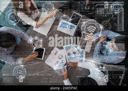 Technologie digitaler virtueller Bildschirm und drahtlose Kommunikation, die sich über die Gesamtansicht der Business People Group bei einem Meeting im modernen Büro verbinden, Stockfoto