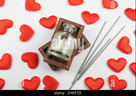 Valentinstag weißen Holz Hintergrund mit Geschenkbox mit Home Aroma Duft Diffusor mit roten Herzen. Valentinstag Geschenk oder Liebe Konzept Stockfoto