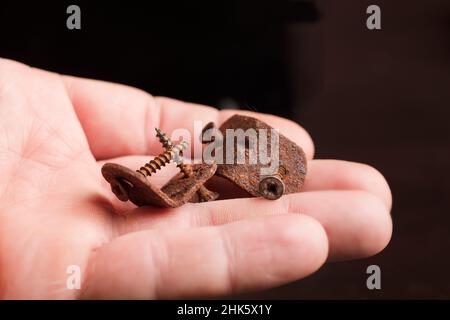 Winkelklammern mit korrosiva ruca, Oxid, in der Hand eines Mannes, Stockfoto