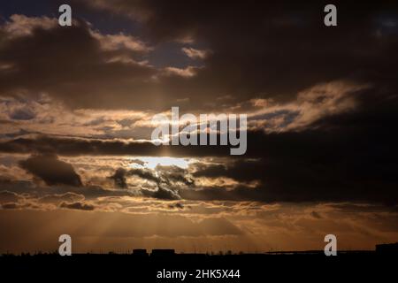 Leipzig, Deutschland. 02nd. Februar 2022. Bei wechselhaftem und windigem Wetter untergeht die Sonne am Flughafen Leipzig/Halle hinter den Wolken. Quelle: Jan Woitas/dpa-Zentralbild/dpa/Alamy Live News Stockfoto