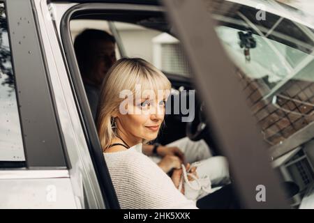 Ein erwachsenes reifes glückliches romantisches Paar verliebt im Freien im Auto. Ein blonder Kaukasusmann und eine blonde Frau verbringen Zeit miteinander. Ältere Frau und Ehemann Stockfoto