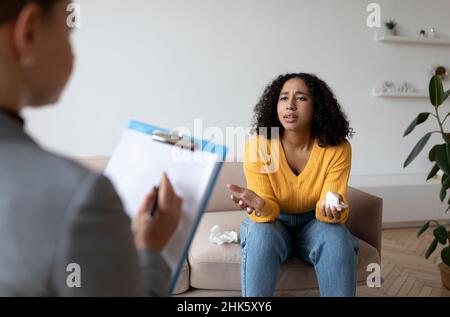 Psychotherapeut, der depressive schwarze Patientin konsultiert und in der Klinik eine Therapiesitzung durchgeführt hat Stockfoto