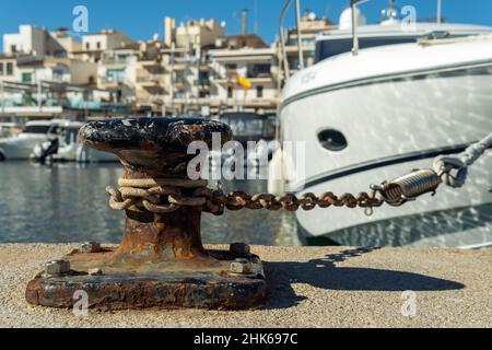 Nahaufnahme einer Anlegestelle aus rostfreiem Eisen, an der eine weiße Luxusyacht festgemacht wird. Portopetro, Insel Mallorca, Spanien Stockfoto