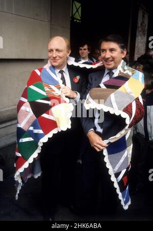 Die britischen Politiker Neil Kinnock und David Steel posieren mit Patchwork-Quilt in London 1986 Stockfoto