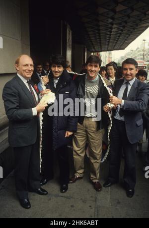 Die britischen Politiker Neil Kinnock und David Steel mit dem Schauspieler Tom Conti, der 1986 in London mit Patchwork-Quilt posiert Stockfoto