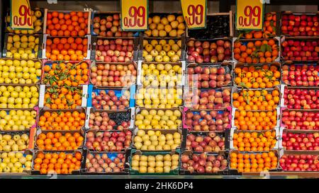 Kisten voller frischer und farbenfroher Früchte werden auf einem Markt mit dem Verkaufspreis ausgestellt Stockfoto