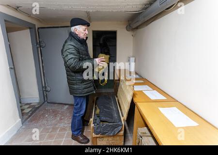 USCHHOROD, UKRAINE - 2. FEBRUAR 2022 - der Katastrophenschutzexperte Anatolii Koboziev demonstriert eine Gasmaske im Bombenschutz des Uschhorod Vodok Stockfoto