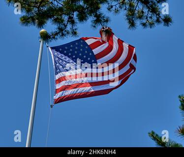 American Flag winkt im Wind mit einem klaren blauen Himmel Hintergrund. Stockfoto