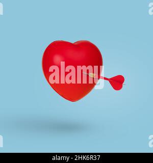 Dart trifft in einem roten Herzen, isoliert auf einem blauen Hintergrund. Minimale Liebe und Valentinstag Konzept. Stockfoto