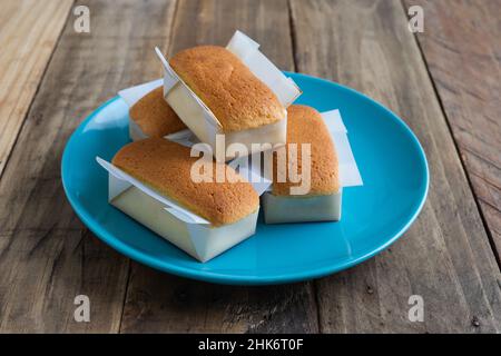 Mantecadas handgemachtes typisch spanisches Dessert. Cupcakes mit blauem Teller auf Holzhintergrund. Speicherplatz kopieren. Stockfoto