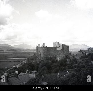 1950s, historisch, ein Blick aus dieser Zeit der Burg Harlech, einer mittelalterlichen Festung auf einem Felsvorsprung und die umliegende walisische Landschaft, Gwynedd, Wales gebaut. Stockfoto