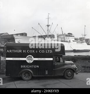 1950s, historisch, ein Lieferwagen von Arthur H. Cox & Co aus Brighton, England, UK in Austin. Geparkt in London legt am Hafen von London an. Das britische Unternehmen wurde 1839 von Arthur Hawker Cox gegründet und war in dieser Zeit ein führender Hersteller und Hersteller von medizinischen Hilfsmitteln, der seine Tabletten und Tabletten in die ganze Welt exportierte. Auch an den Docks, das norwegische Frachtschiff, 'Nördliche Lichter'. Stockfoto