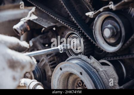 Der Automotor wird von der Seite des Riemens und der Steuerrollen in geringer Schärfentiefe demontiert Stockfoto