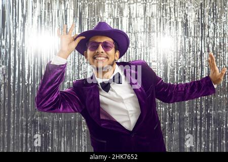 Fröhlicher, stylischer, dunkelhäutiger junger Mann im eleganten Cord-Anzug arrangiert Disco-Party. Stockfoto